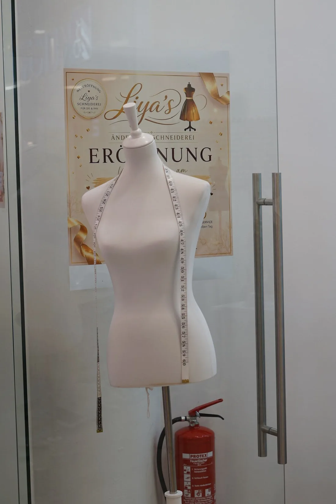Schaufenster von Liya's Änderungsschneiderei mit Schneiderpuppe und Maßband im Untergeschoss der Erlangen Arcaden